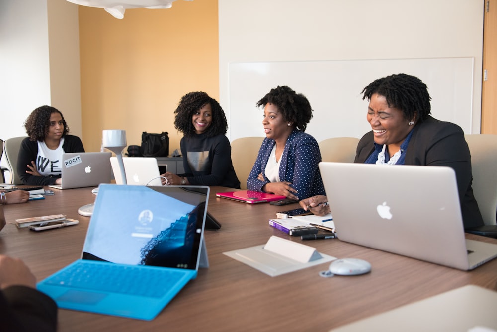 A team working together on laptops around a meeting table